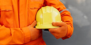 front-view-worker-uniform-holding-hard-hat_23-2148773469